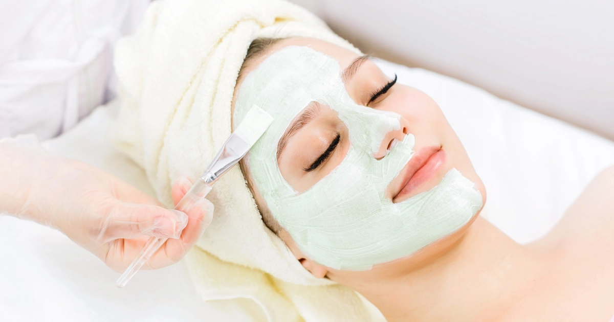 Woman receiving a relaxing skincare facial in Pasadena, CA with a green face mask